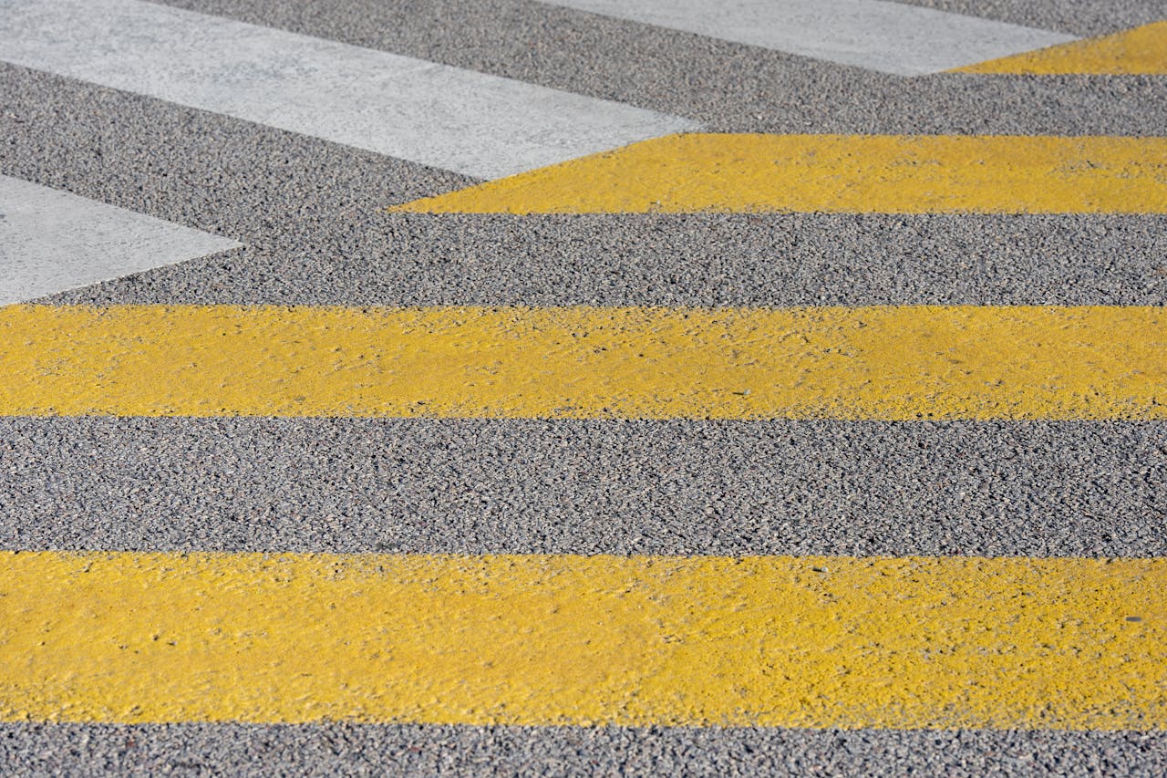 Diagonal crosswalk stripes create a vibrant street pattern with yellow and white lines.